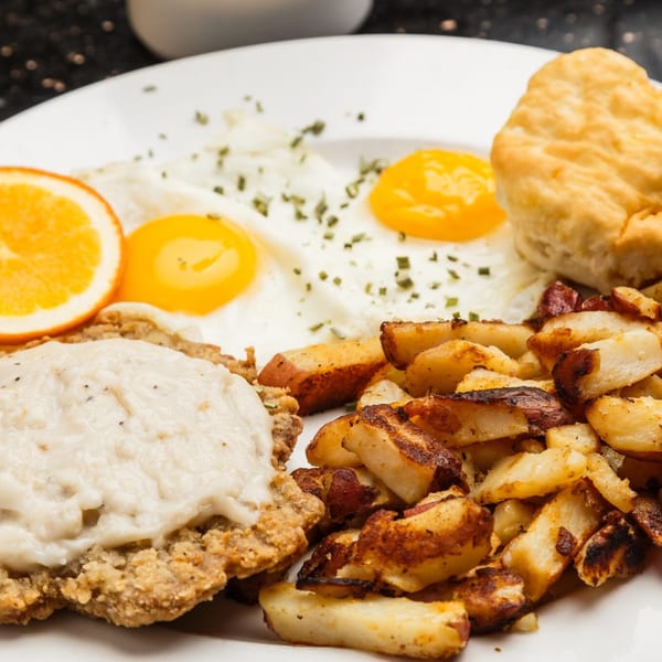 That Flippin' Egg's breakfast plate with chicken fried steak, eggs, home fries, biscuit, and orange.